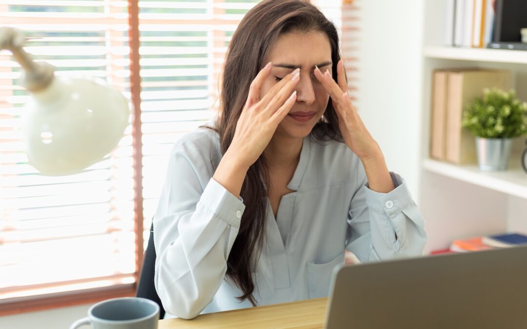 Woman pressing her fingers to her face with discomfort, possibly experiencing sinus-like headache from muscle tension or trigger point referral.