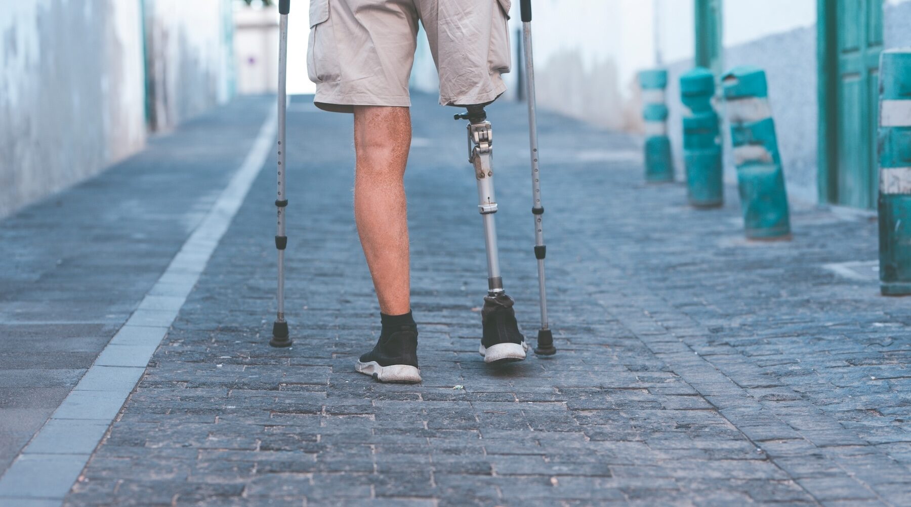 Testimonial: Mobility Recovery After Amputation at Body Kneads Man with a prosthetic leg walking with crutches - a long-term disability patient rehabilitated with Dena Denali